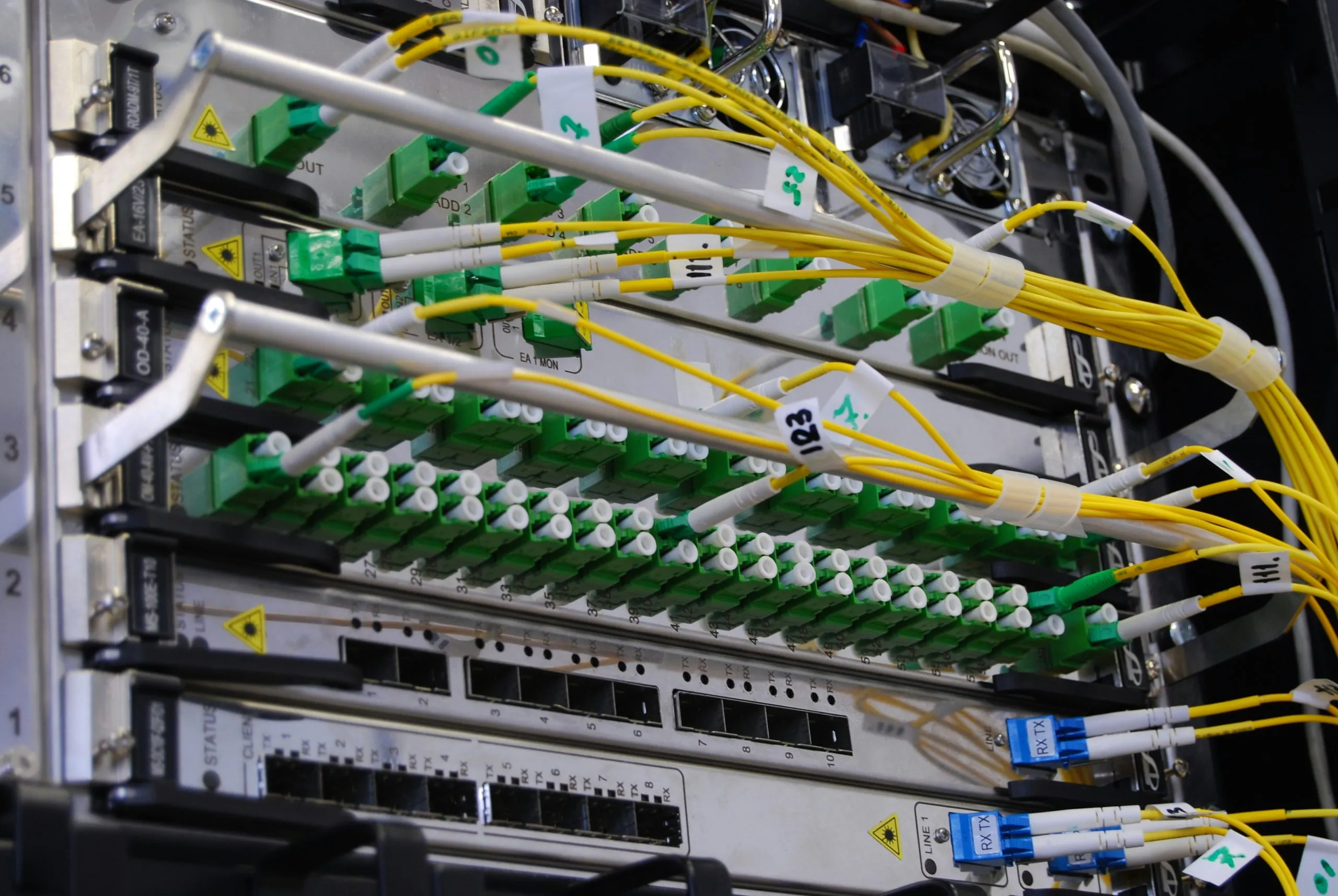 kirill-sh-eVWWr6nmDf8-unsplash-scaled-cmp Photo of an optical networking patch panel.